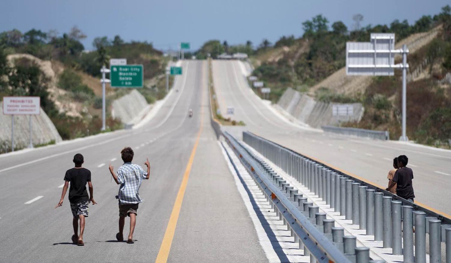 Young boys on an empty highway near Suai in Timor-Leste, built by the China Railway Group, 24 August 2019. (Photo: Dimas Ardian via Getty)