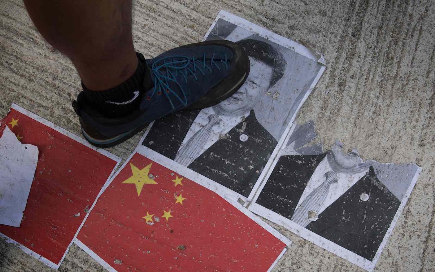 A protester treads on an image of Chinese President Xi Jinping in Hong Kong on 1 October 2019, the National Day marking the 70th anniversary of communist China’s founding. (Photo: Mark Ralston/AFP via Getty)
