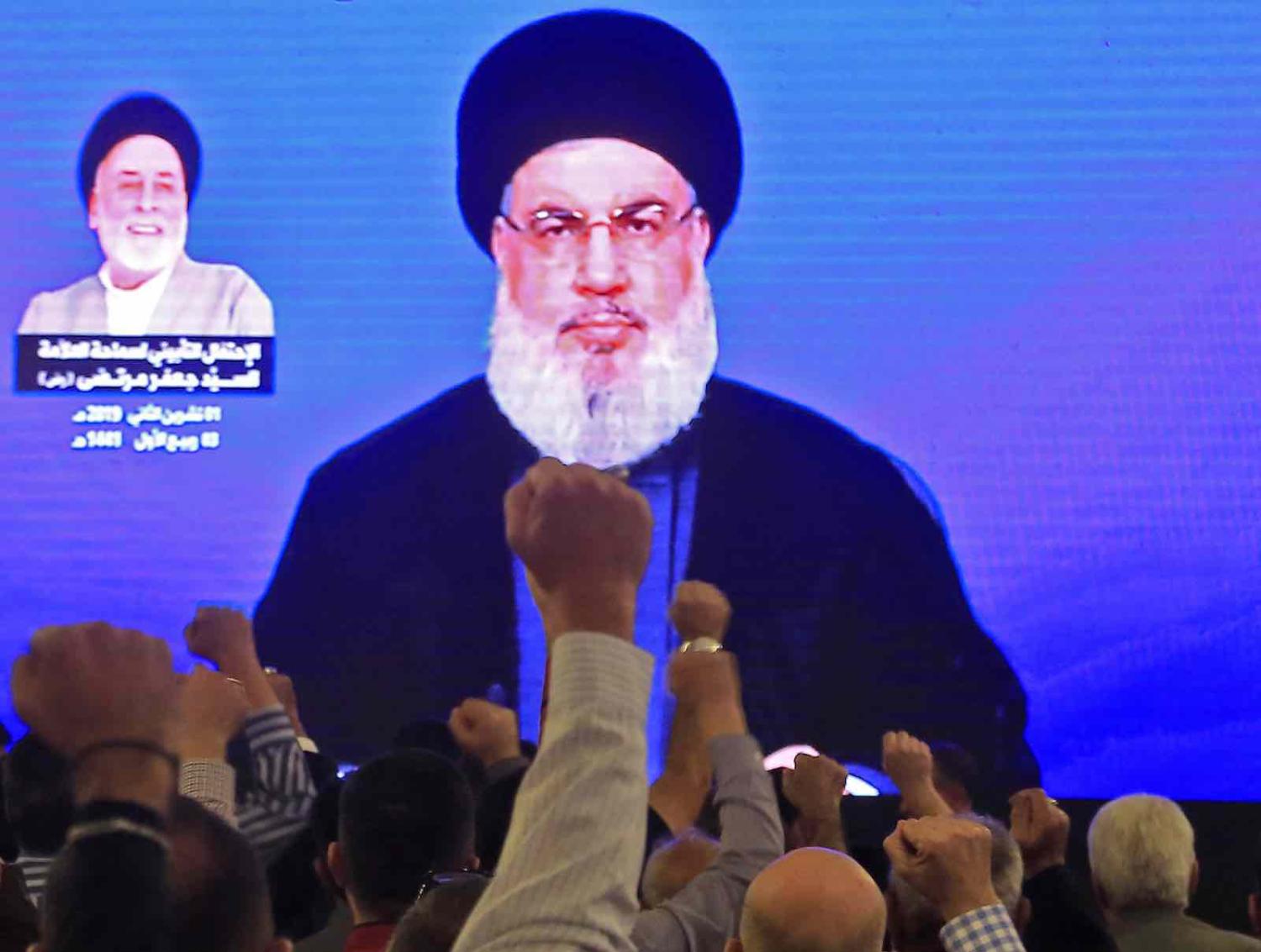 Supporters of Hassan Nasrallah, the head of Lebanon’s militant Hezbollah movement, watch him speak through a giant screen at a mosque in Beirut’s southern suburbs on 1 November (Photo: AFP via Getty Images)