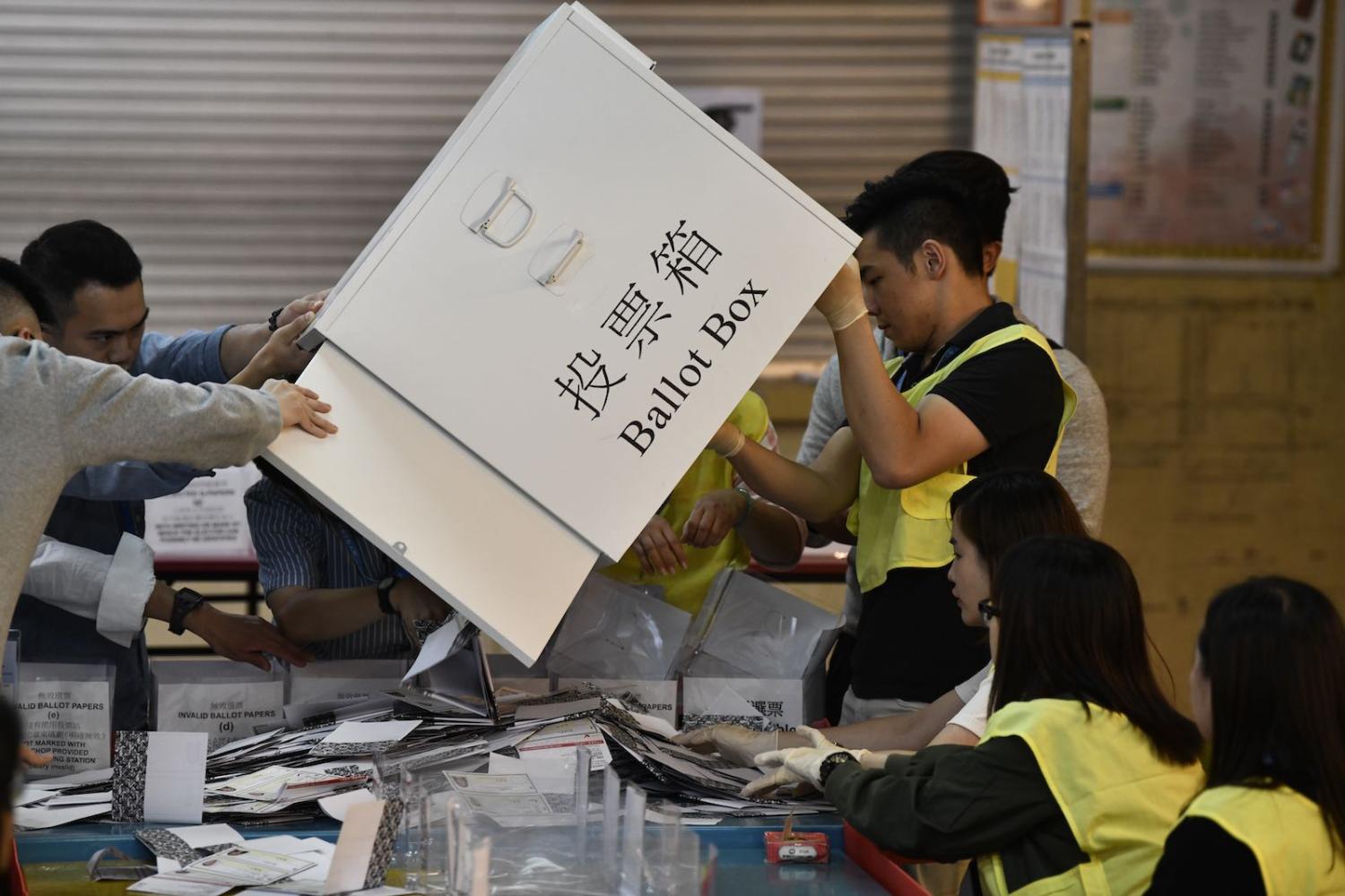 Officials unload a ballot box at a counting station during the District Council elections in Tuen Mun in Hong Kong, 24 November (Photo: Vernon Yuen/NurPhoto via Getty Images)