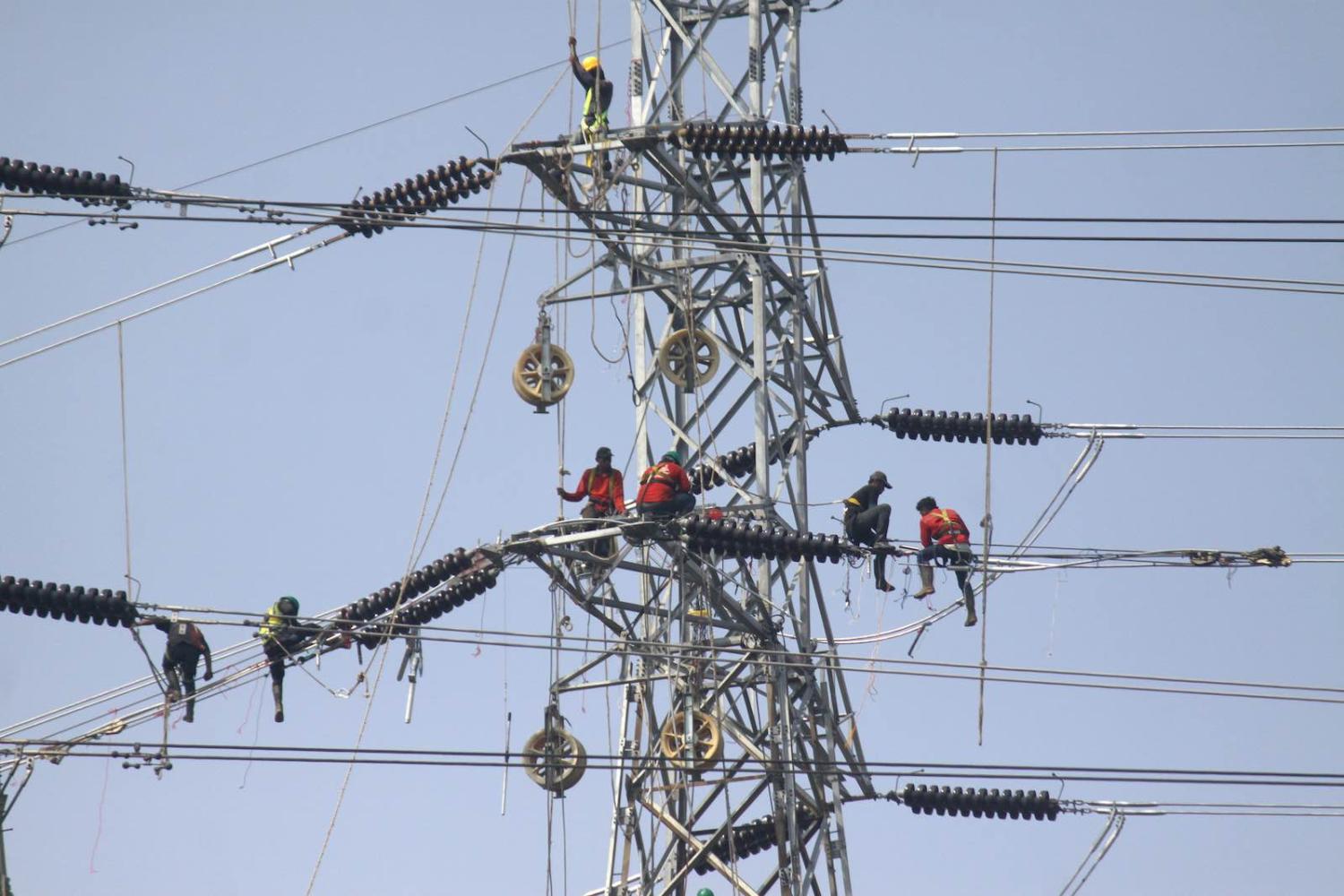 Workers installing high voltage lines for a 35,000 MW electricity project in Jakarta, December 2019 (Aditya Irawan/NurPhoto via Getty Images)