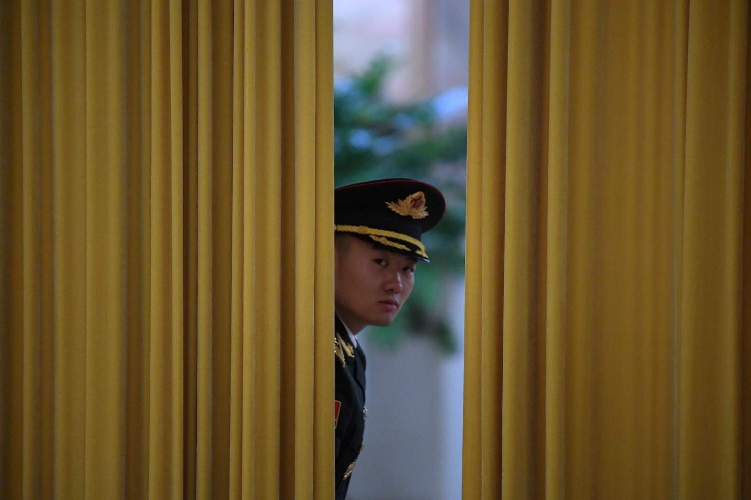 A Chinese honour guard peeks through a curtain before a welcome ceremony for Micronesia's President David Panuelo at the Great Hall of the People in Beijing in December (Photo: Noel Celis/AFP/Getty Images)