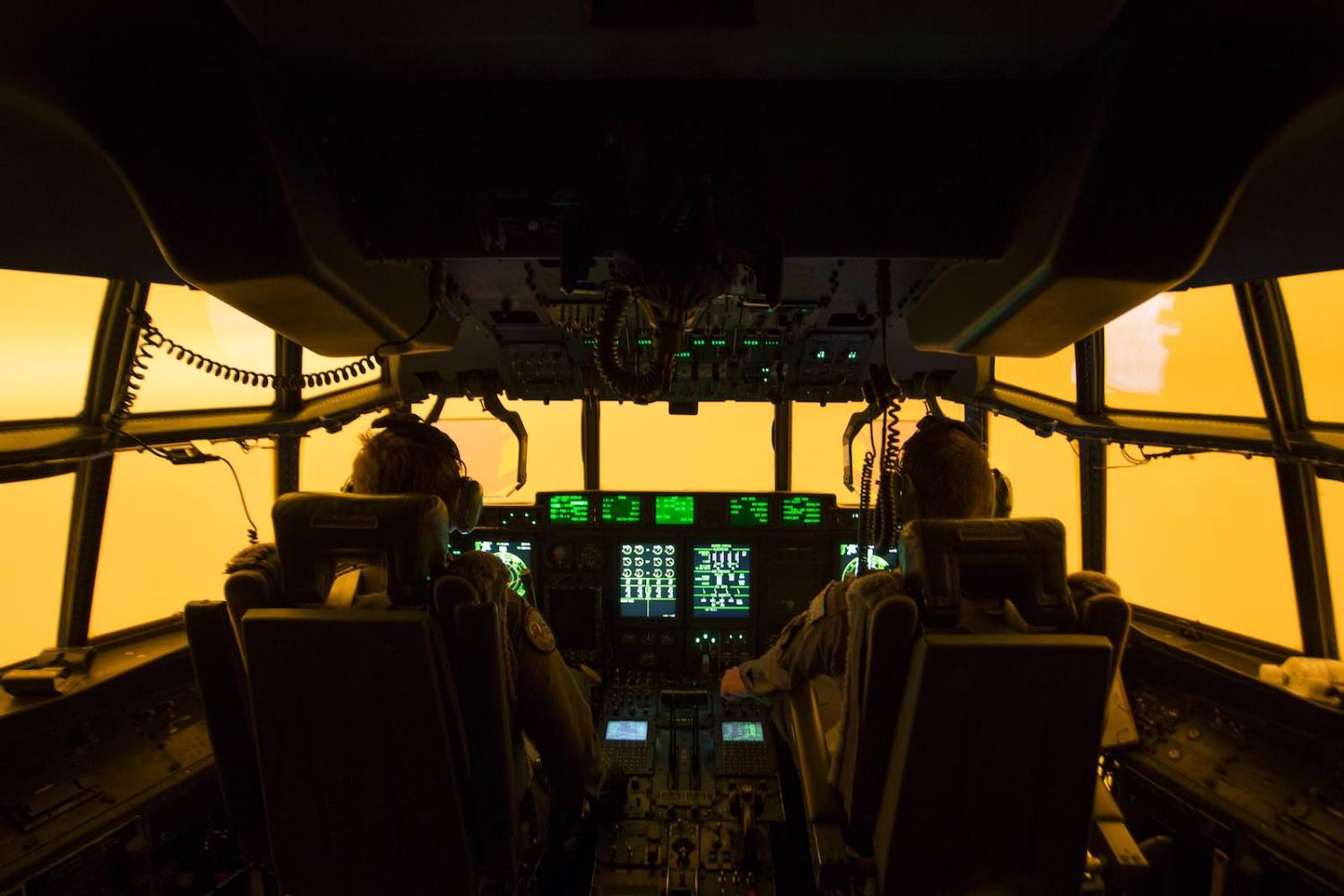 The flight deck lit by the glow of fires, an aircrew attempt a landing to drop off Fire and Rescue crews to assist fighting bushfires, 5 January in Merimbula, Australia (Photo: Australian Department of Defence via Getty Images)