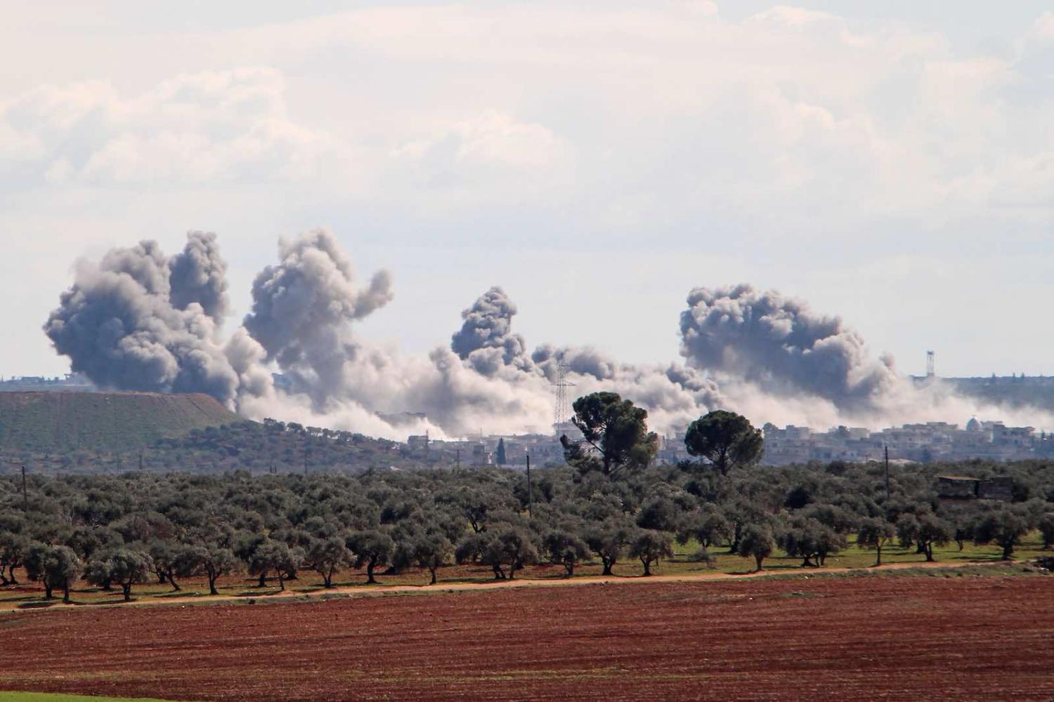 Smoke from what is reported to be Russian air strikes reported Russian air strikes in northwestern Syria on 1 March (Ibrahim Yasouf/AFP/Getty Images)