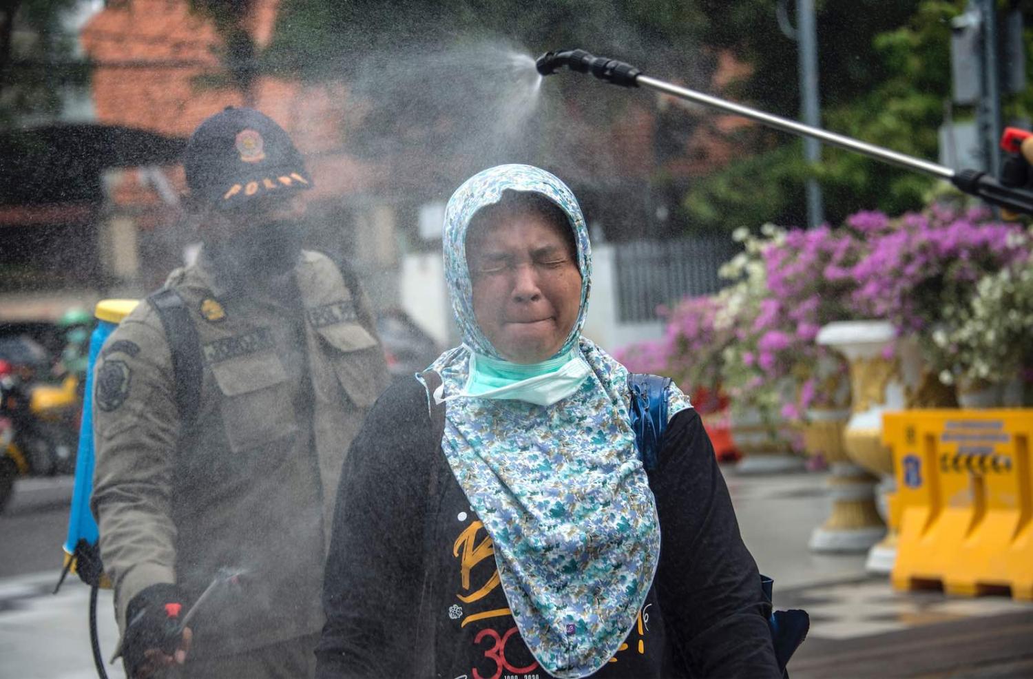 A woman is sprayed with disinfectant on Monday before entering a local government office as a precautionary move against the spread of the Covid-19 coronavirus in Surabaya, Indonesia (Juni Kriswanto/AFP/Getty Images)