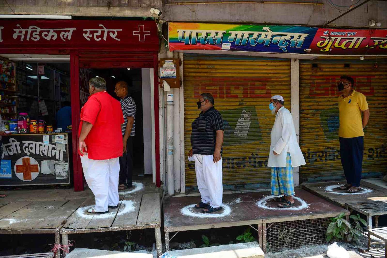 Customers queue outside a pharmacy on the first day of a 21-day national lockdown, Allahabad, India, 25 March