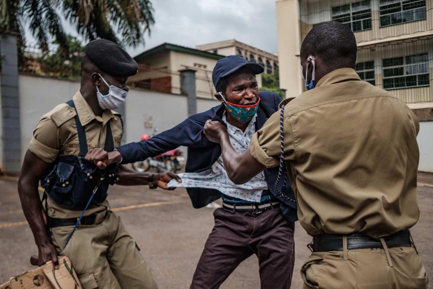 A demonstrator is arrested by police at a protest for more government food distributions during the Covid-19 crisis, 18 May in Kampala, Uganda (Sumy Sadurni/AFP via Getty Images)