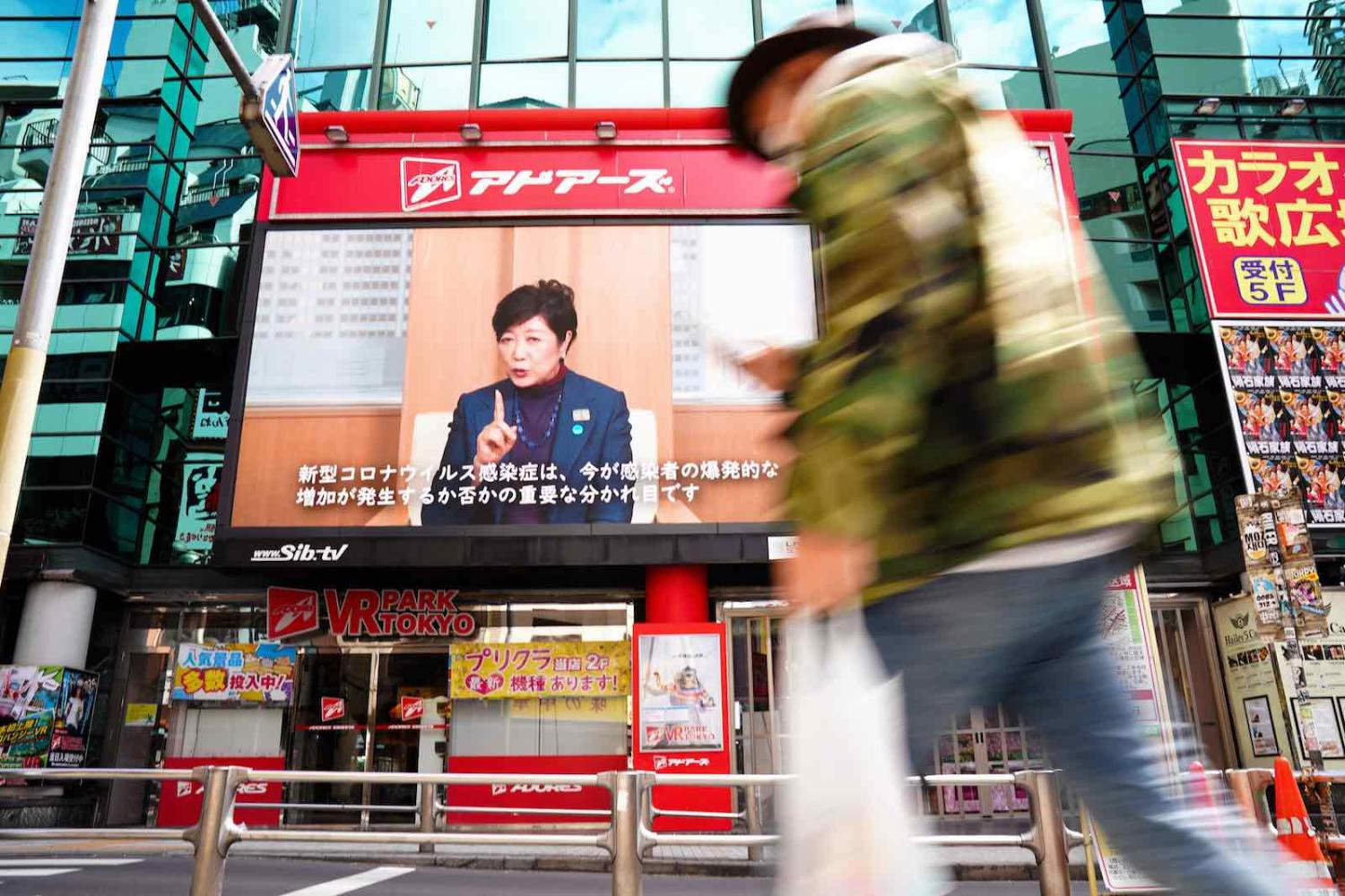 Governor Yuriko Koike on a video screen in Tokyo’s Shibuya district requesting residents to follow Covid-19 stay-at-home orders, 11 April 2020 (Asahi Shimbun via Getty Images)