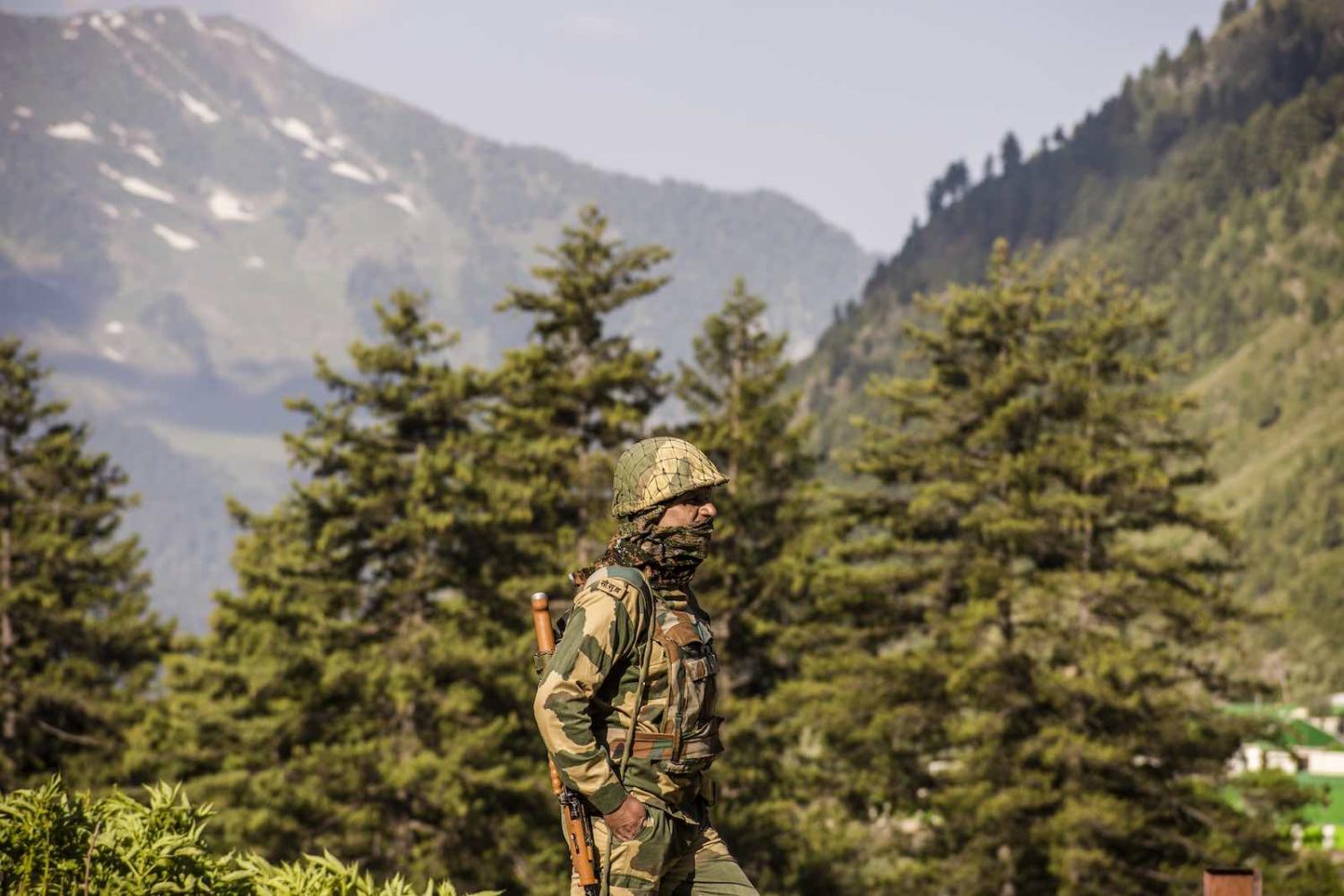 An Indian Border Security Force soldier guards a highway as Indian army convoy travels towards Leh, bordering China, on 19 June in Gagangir, India (Yawar Nazir/Getty Images)