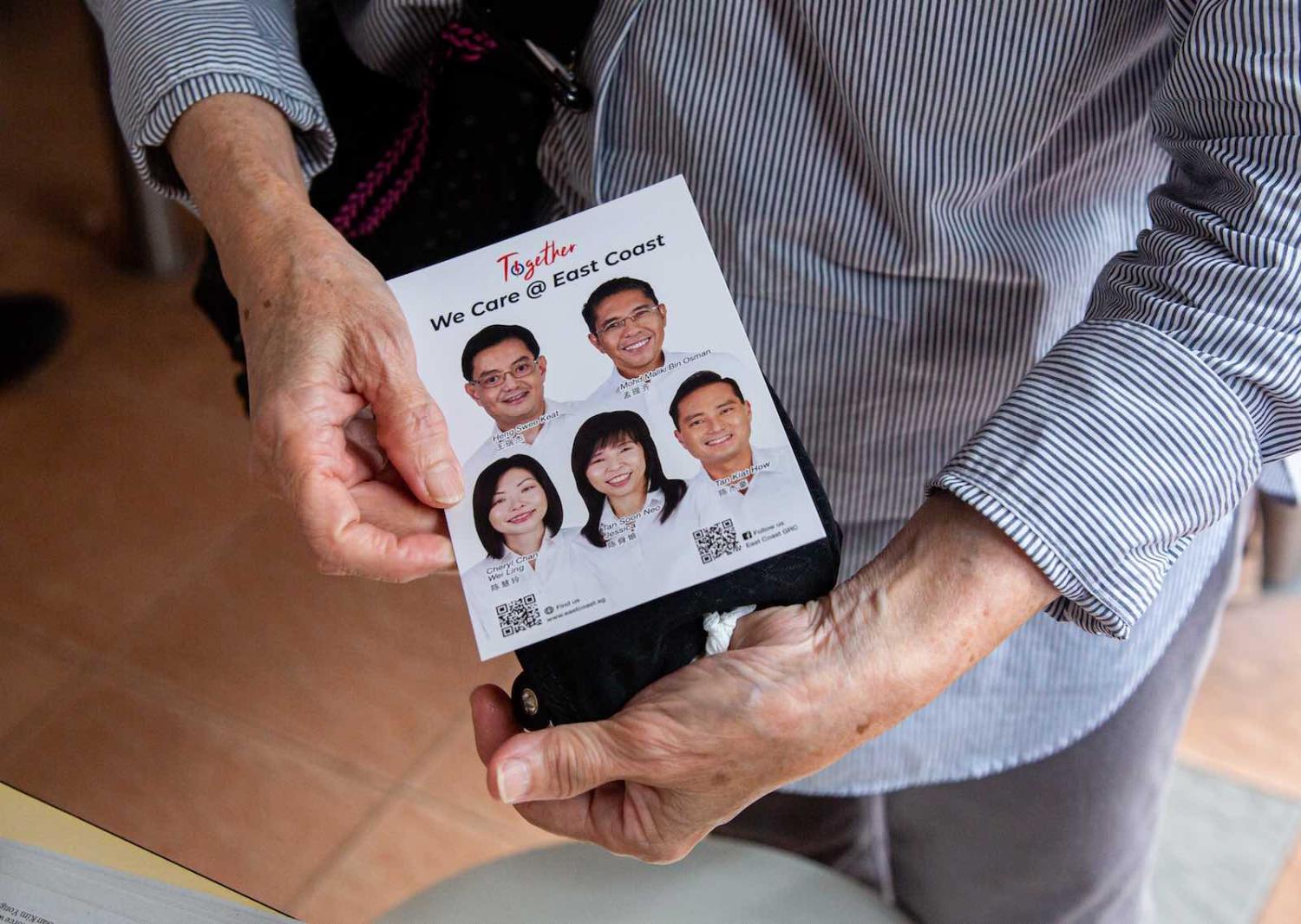 A resident holds a PAP campaign leaflet of East Coast Group Representation Constituency, 3 July 2020 (Ore Huiying/Getty Images)