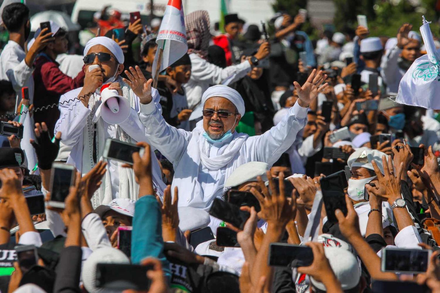 Muslim cleric Rizieq Shihab gestures to supporters as he arrives to inaugurate a mosque in Bogor, Indonesia, 13 November (Rangga Firmansyah/NurPhoto via Getty Images)