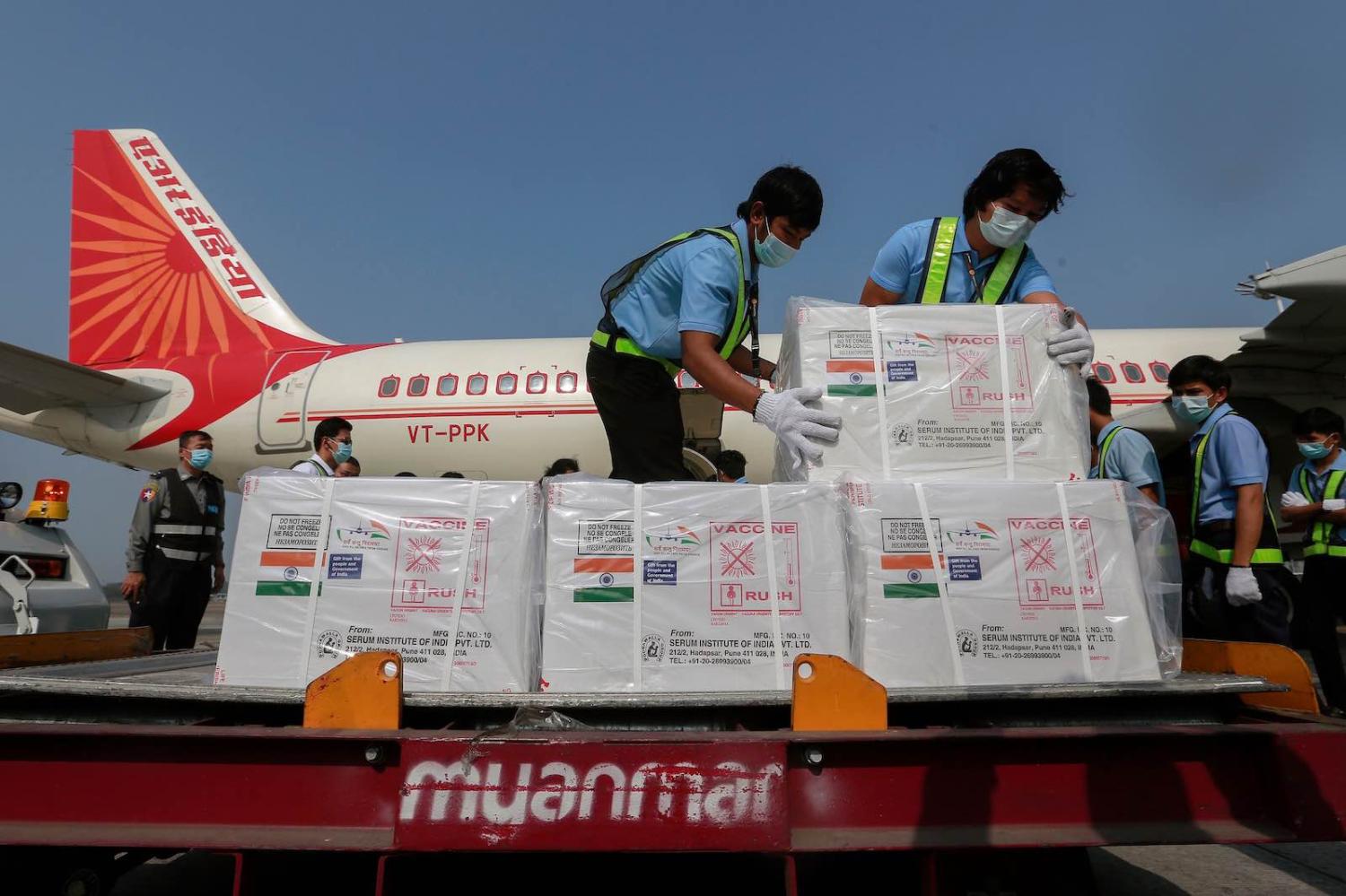 Workers in Myanmar unload a shipment of Covid-19 vaccine manufactured in India (STR/AFP via Getty Images)