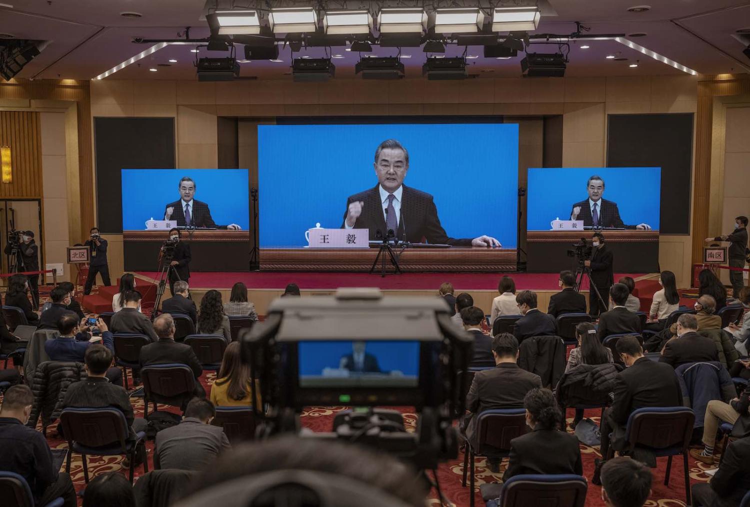 China’s Foreign Minister Wang Yi speaks during a video news conference as part of the National People's Congress, 7 March in Beijing (Kevin Frayer/Getty Images)