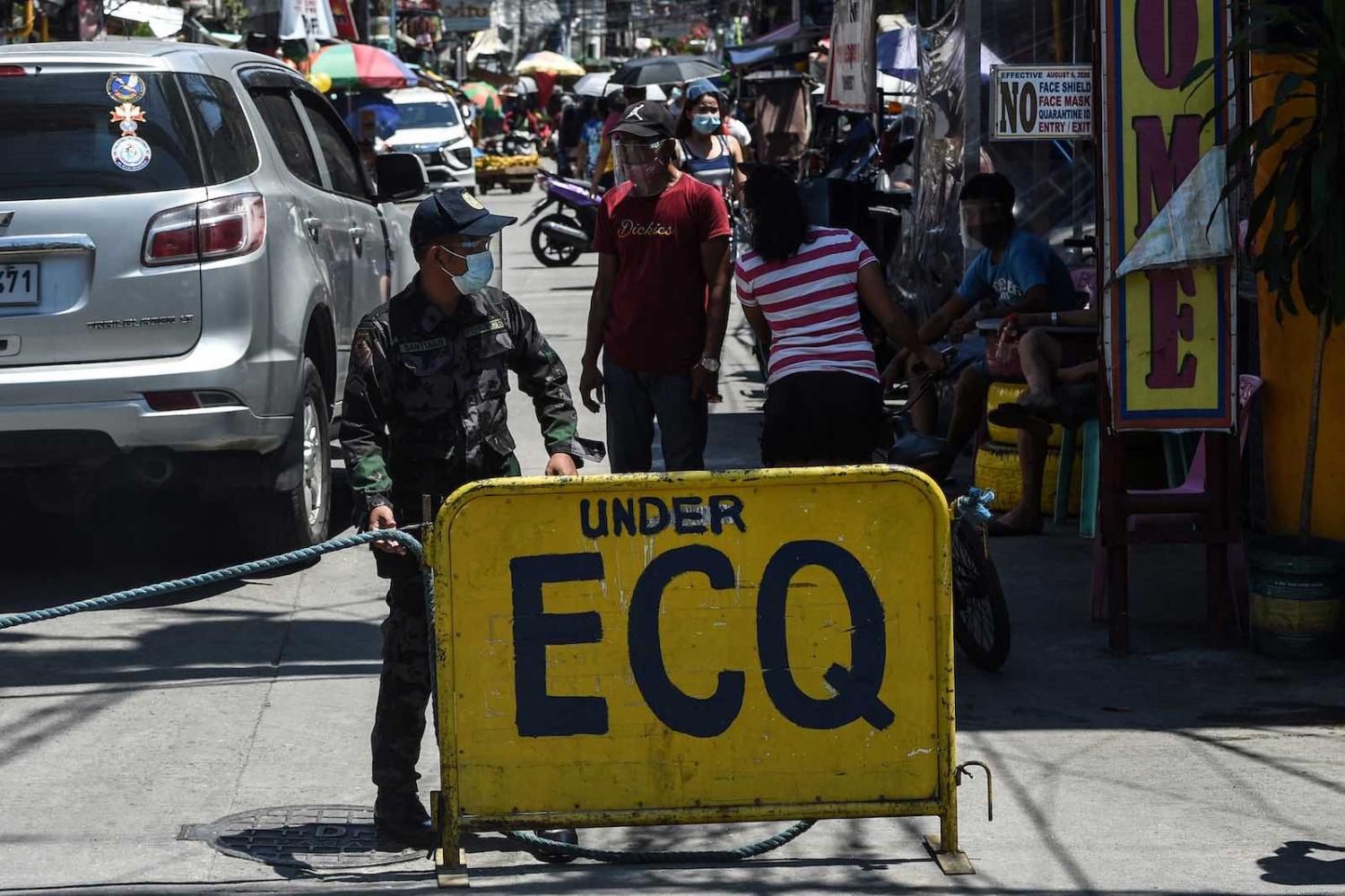 A policeman guards the entrance to a Manila neighbourhood under strict quarantine, 16 March (Ted Aljibe/AFP via Getty Images)