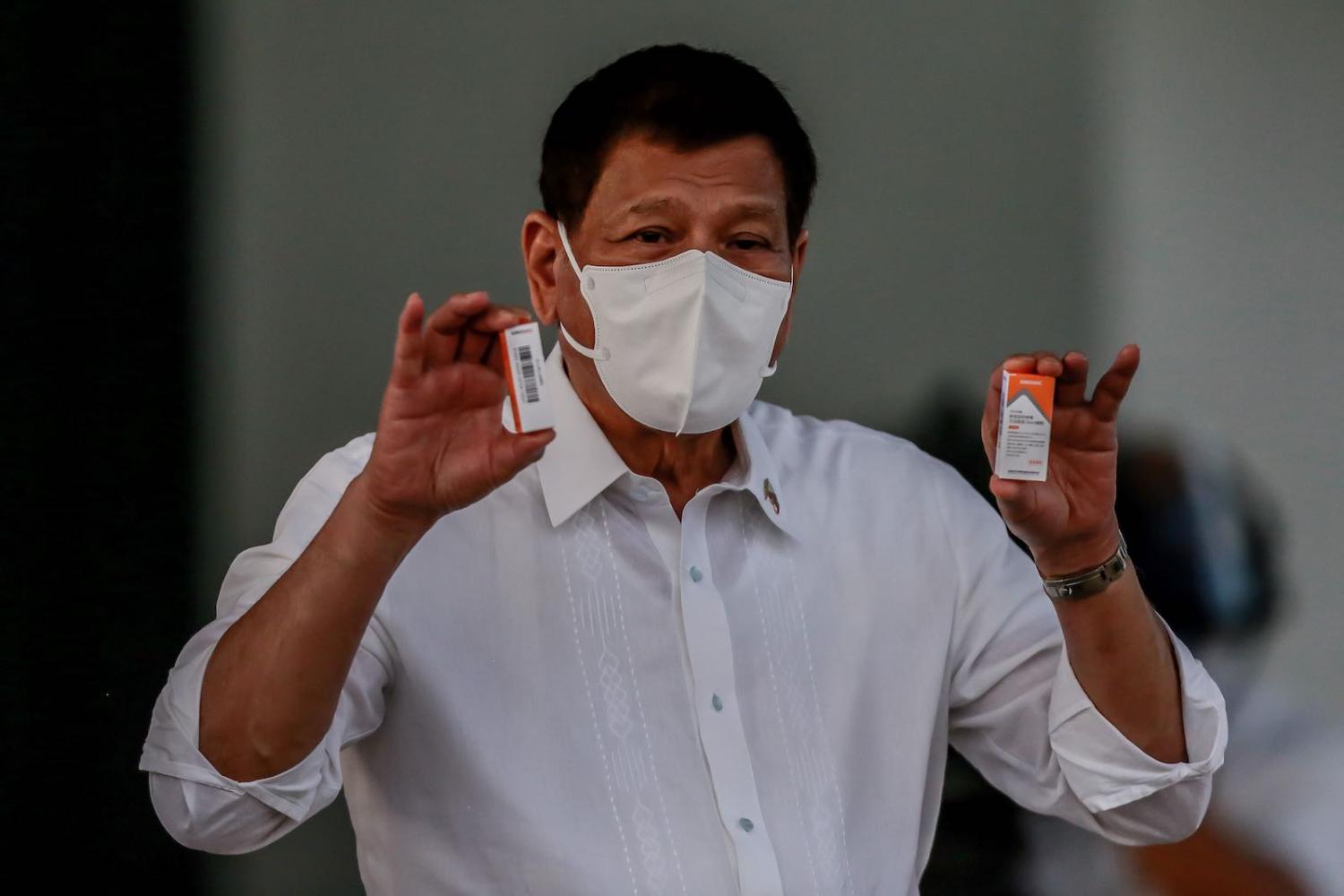Philippine President Rodrigo Duterte shows boxes of newly arrived Sinovac Covid-19 vaccines purchased from China, 29 March 2021 in Manila (Xinhua/Rouelle Umali via Getty Images)