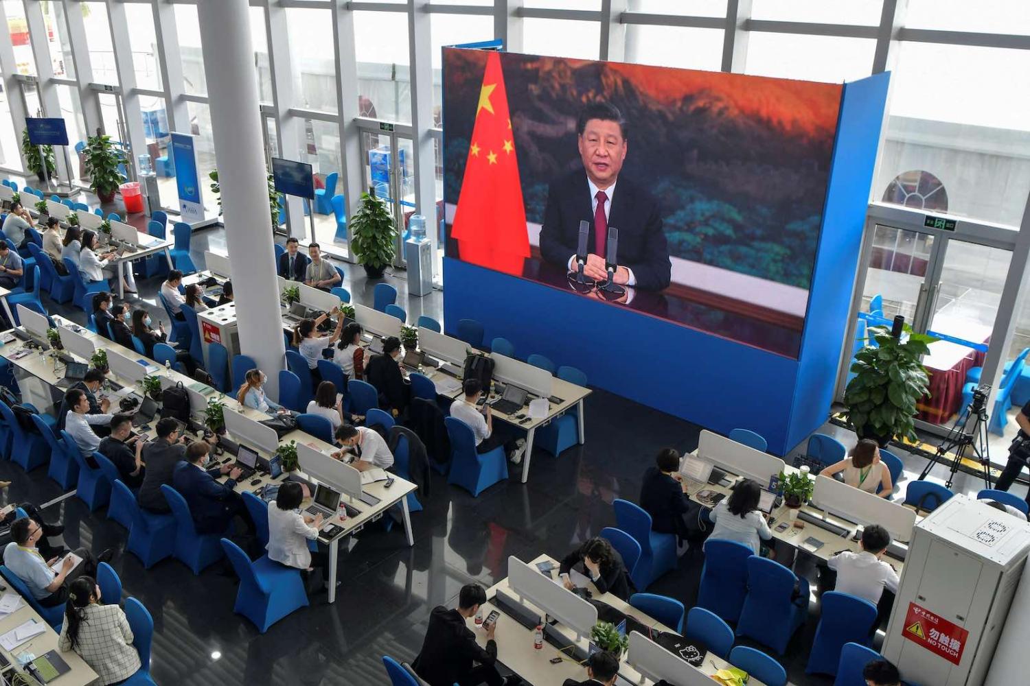 Journalists watch on screen as China’s President Xi Jinping delivers a speech during the opening of the Boao Forum for Asia on 20 April (STR/AFP via Getty Images)