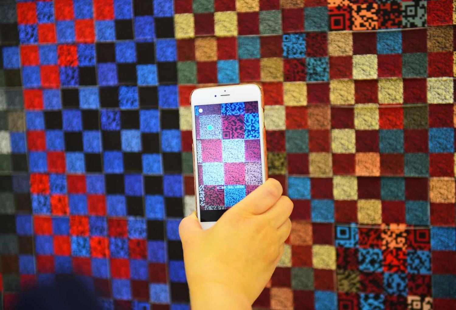 A visitor scans the QR code on an exhibit at an exhibition of traditional crafts in Urumqi, Xinjiang (Hou Zhaokang/Xinhua via Getty Images)