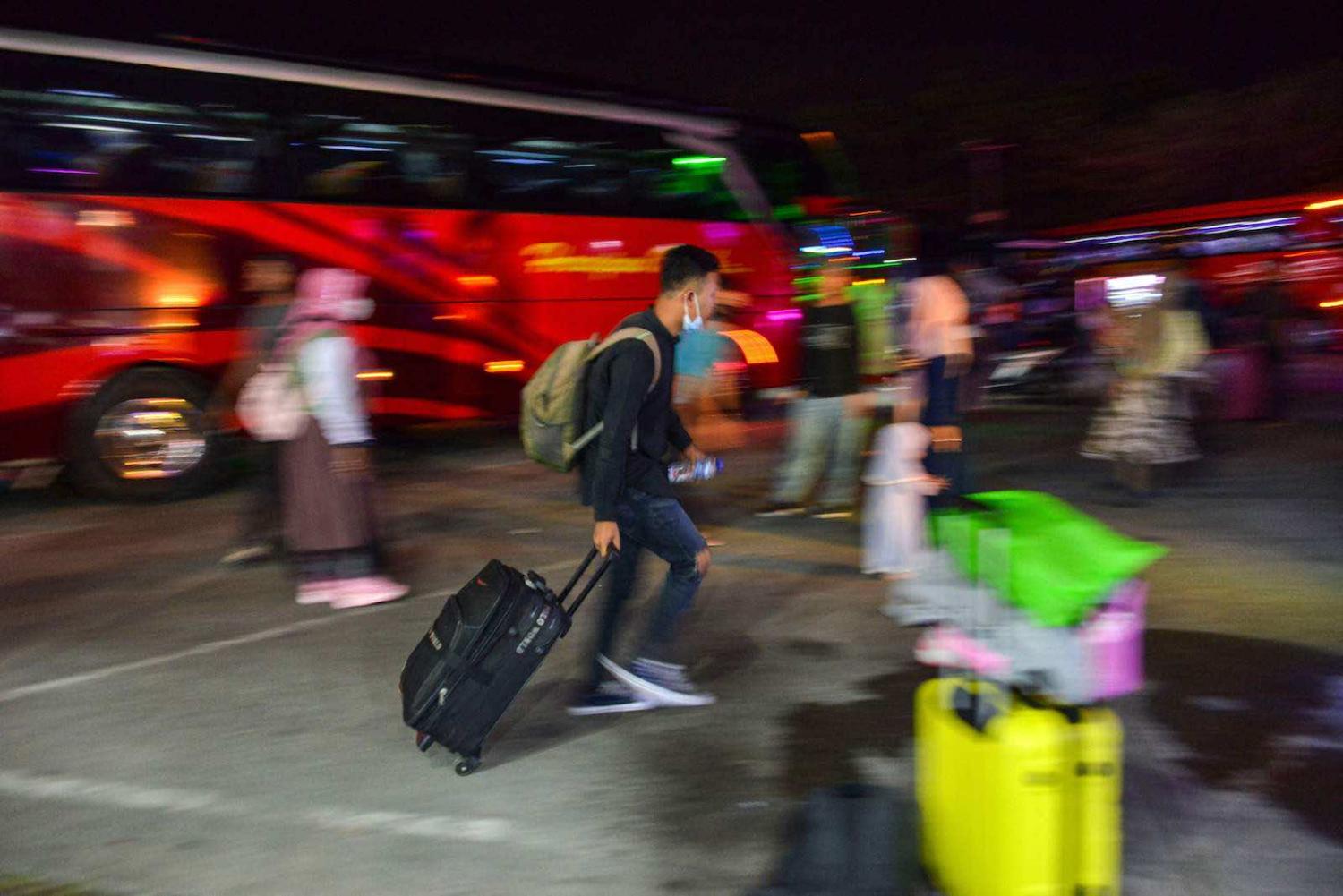 Passengers gather at a bus station during the homecoming, or mudik, ahead of the Eid al-Fitr celebrations in Banda Aceh, 3 May 2021 (Chaideer Mahyuddin/AFP via Getty Images)