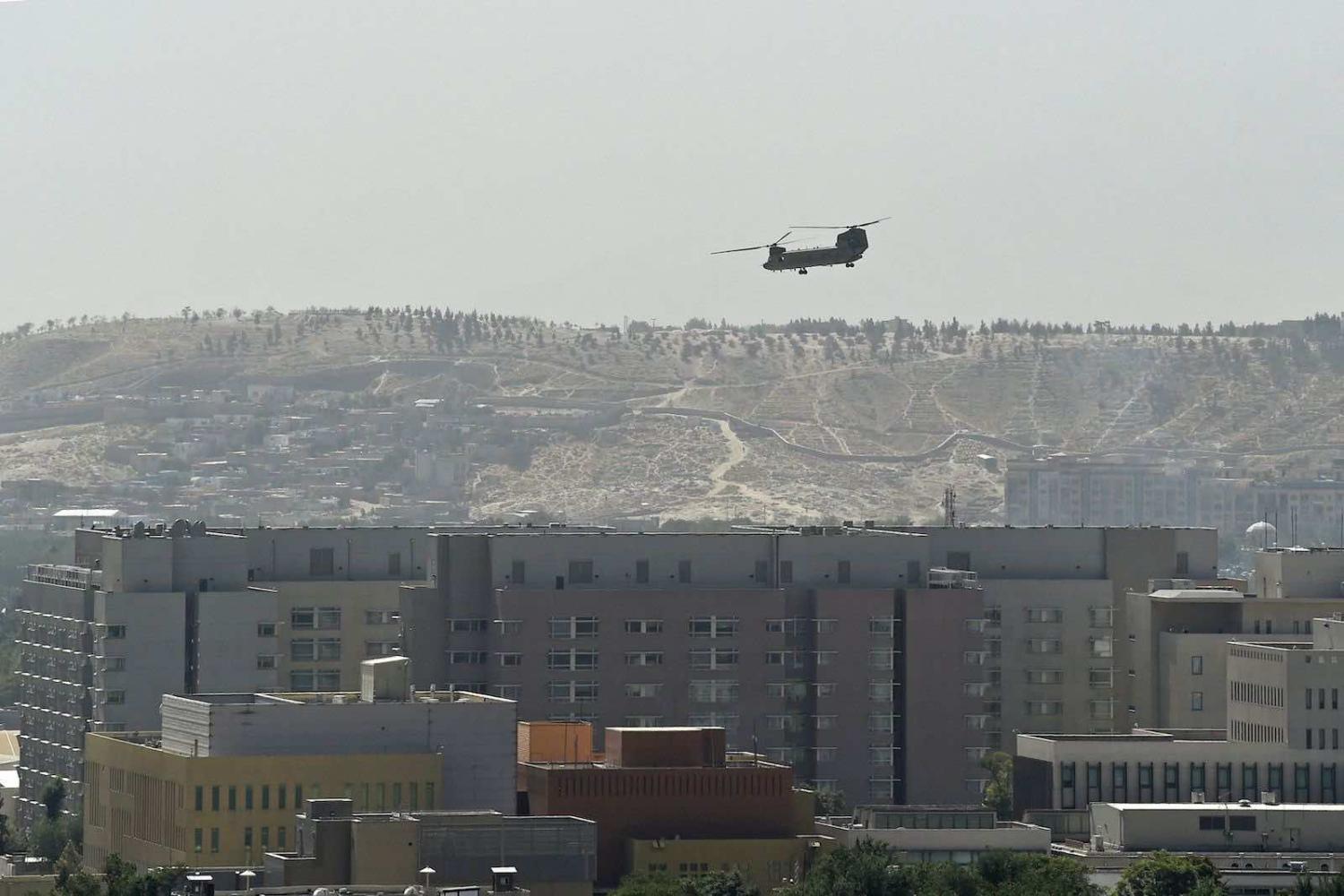 A US military helicopter is pictured flying above the US embassy in Kabul on 15 August (Wakil Kohsar/AFP via Getty Images)