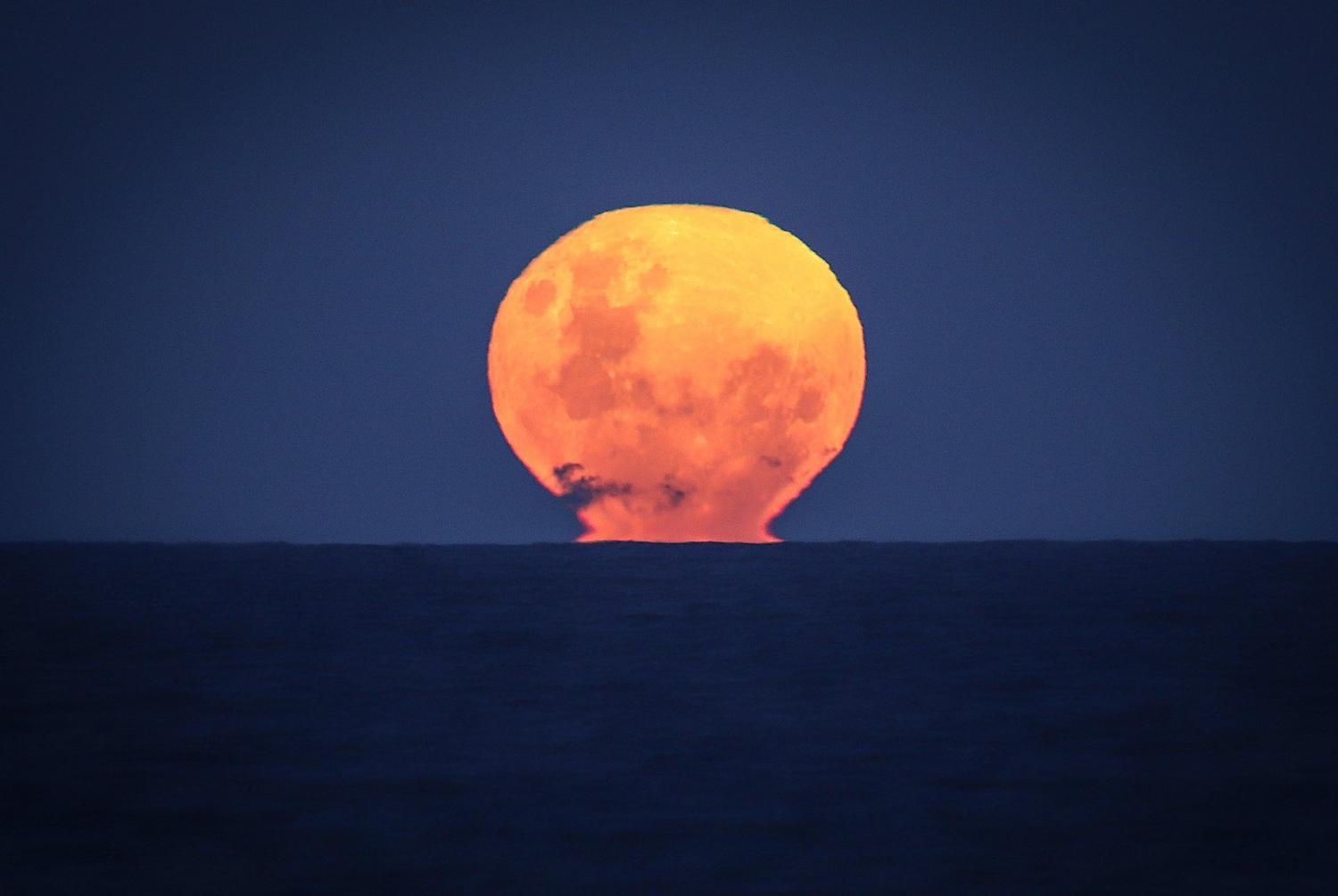 Moonrise over the Pacific ocean at Narrawallee Beach, on the south coast of New South Wales in Australia, 6 June 2020 (David Gray/Getty Images)