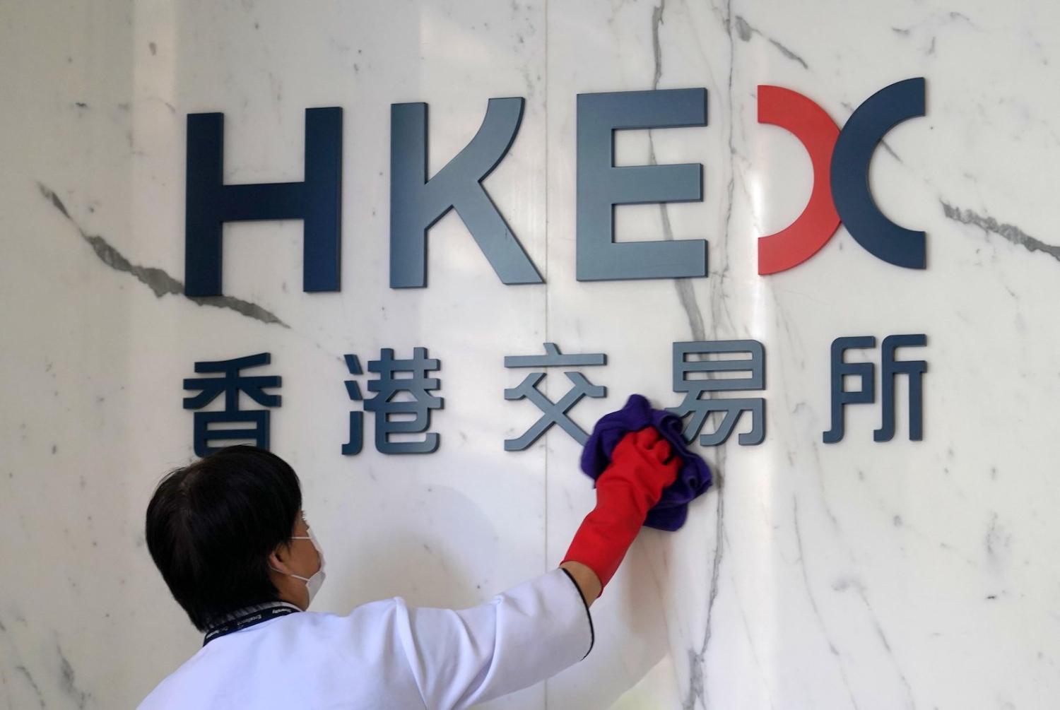 A worker cleans the logo of Hong Kong Exchanges and Clearing (HKEX), June 2020 (Zhang Wei/China News Service via Getty Images)