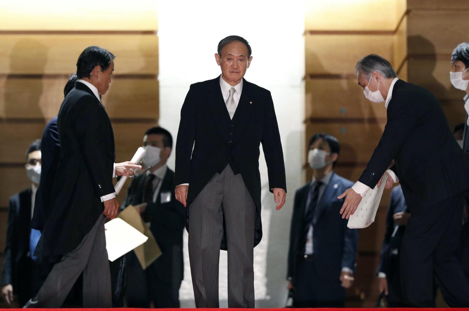 Japan’s Prime Minister Yoshihide Suga arrives for a group photograph with his cabinet at the prime minister’s residence, 16 September 2020 in Tokyo (Issei Kato/Pool/Getty Images)
