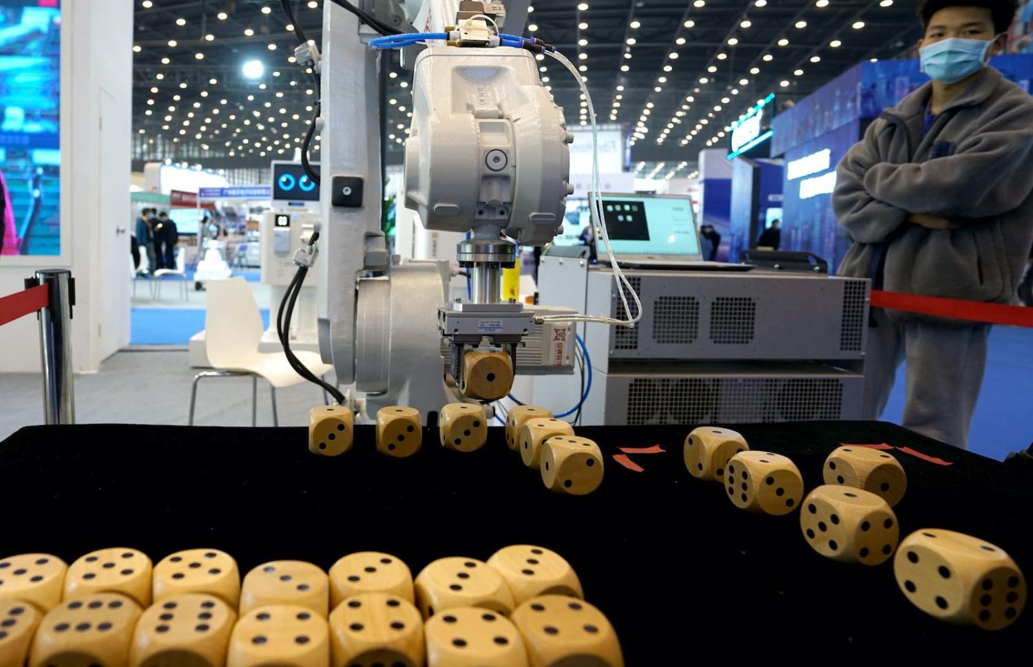 A robotic arm arranges dice during the 2021 World Digital Industry Expo in Zhengzhou, Henan province, China, 24 March 2021 (Ma Jian/VCG via Getty Images)