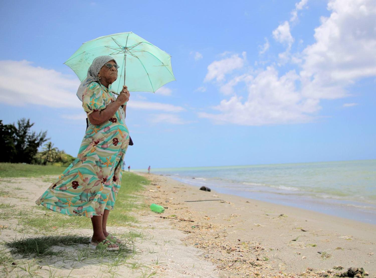 A 90-year-old woman who was exiled from the Peros Banhos Atoll of the Chagos Archipelago stands by the sea in March 2015 in Port Louis, Mauritius (The Asahi Shimbun via Getty Images)