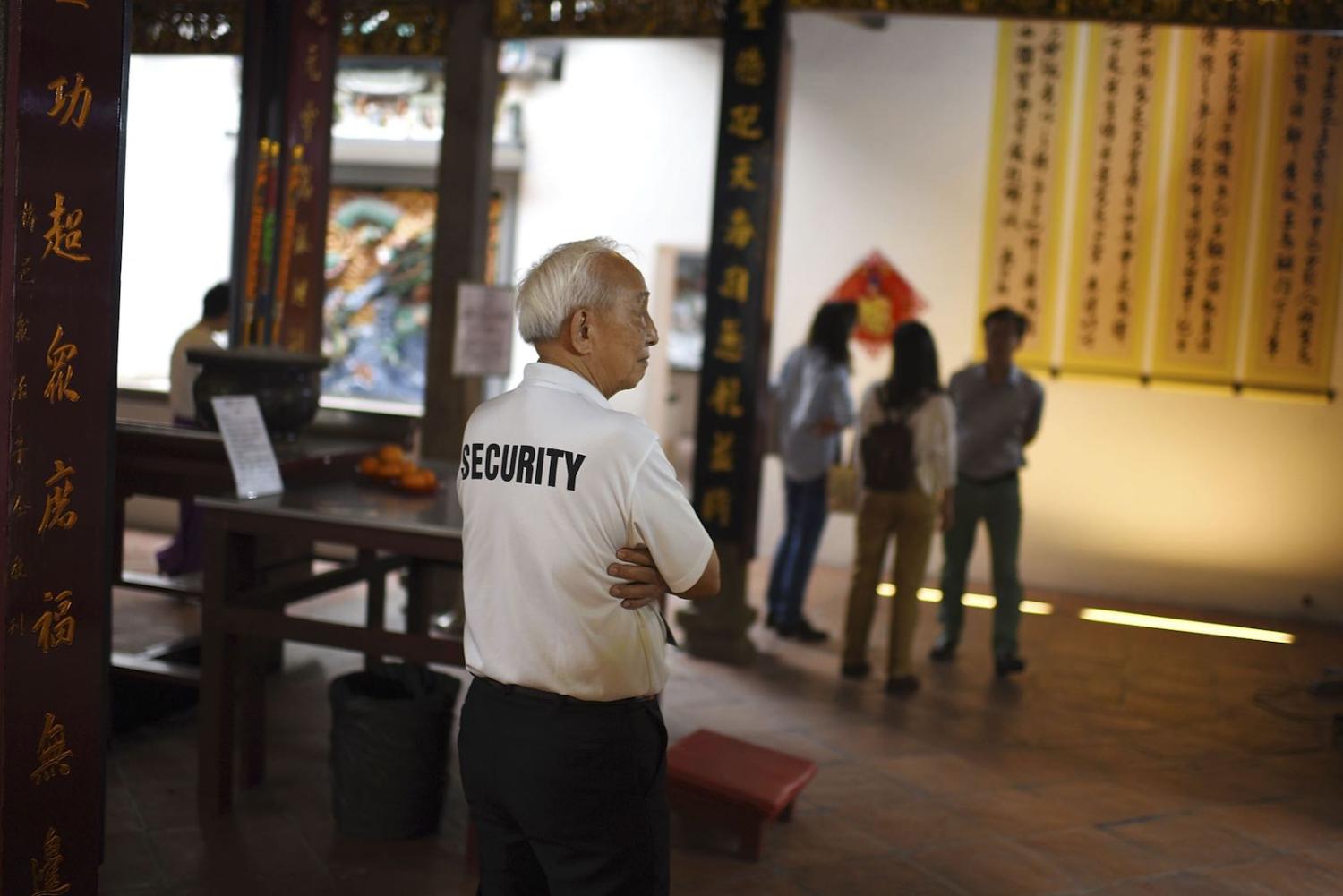 Wong, a 72-year-old security guard, keeps watch at temple during the Chinese New Year in Singapore, February 2016. (Borja Sanchez-Trillo/Getty Images)