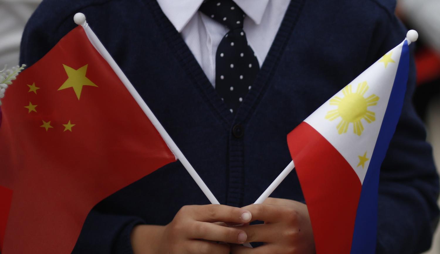 Children hold national flags during Philippine President Rodrigo Duterte’s visit to Beijing in 2016 (Photo: Thomas Peter-Pool/Getty)