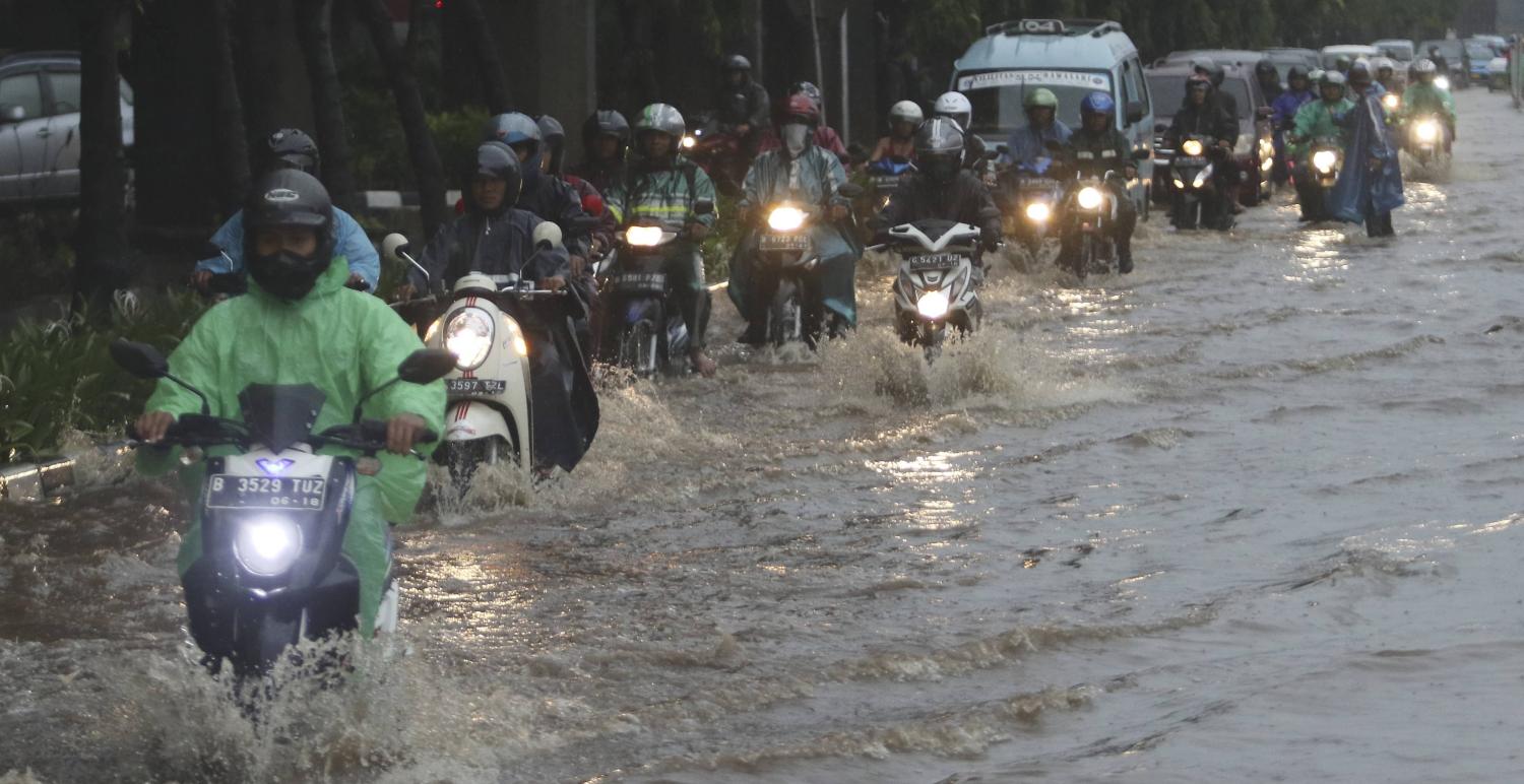 Motorcyclists pass floodwaters in easter Jakarta in December (Photo: Eko Siswono Toyudho/Getty)