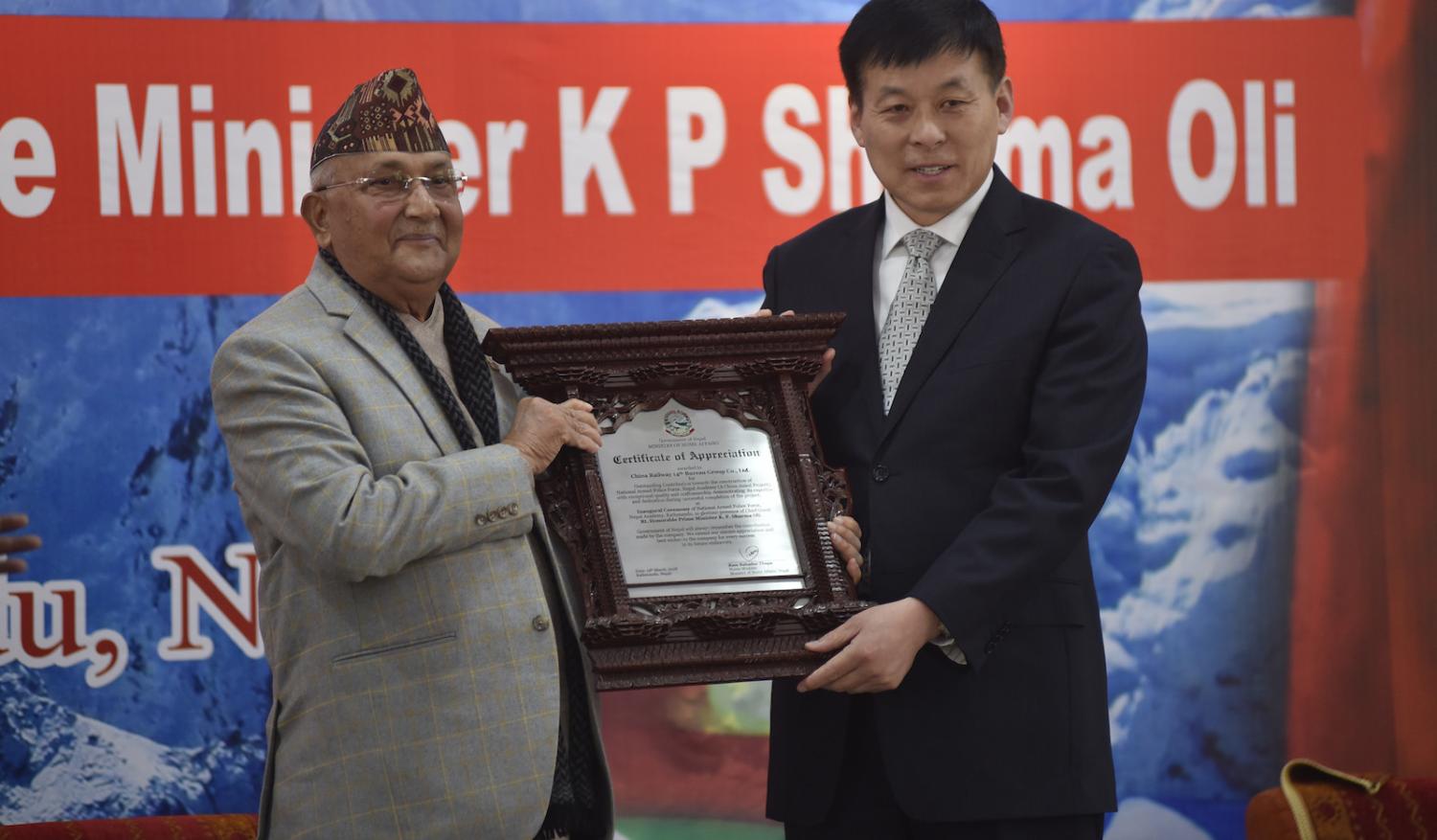 Prime Minister of Nepal KP Sharma Oli giving Certificate of Appreciation to the member of China Railway 14th Bureau Group (Photo: Photo by Narayan Maharjan via Getty)