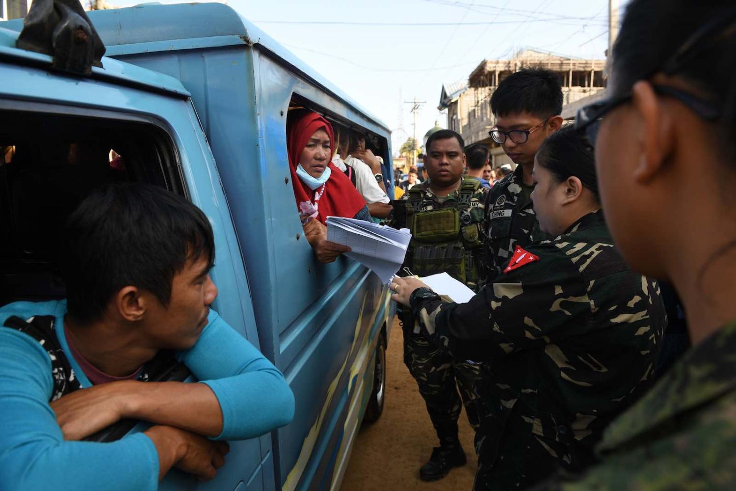 Soldiers check identity documents of residents allowed to visit their destroyed houses at the main battle area in Marawi City (Photo: Ted Aljibe/AFP/Getty Images)