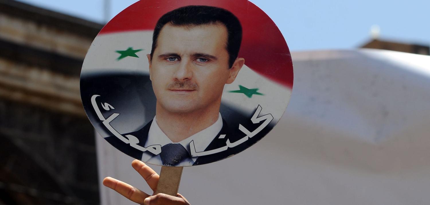 Yemeni protesters hold a photo of Syrian President Bashar al-Assad following US-led airstrikes (Photo: Mohammed Hamoud/Getty)