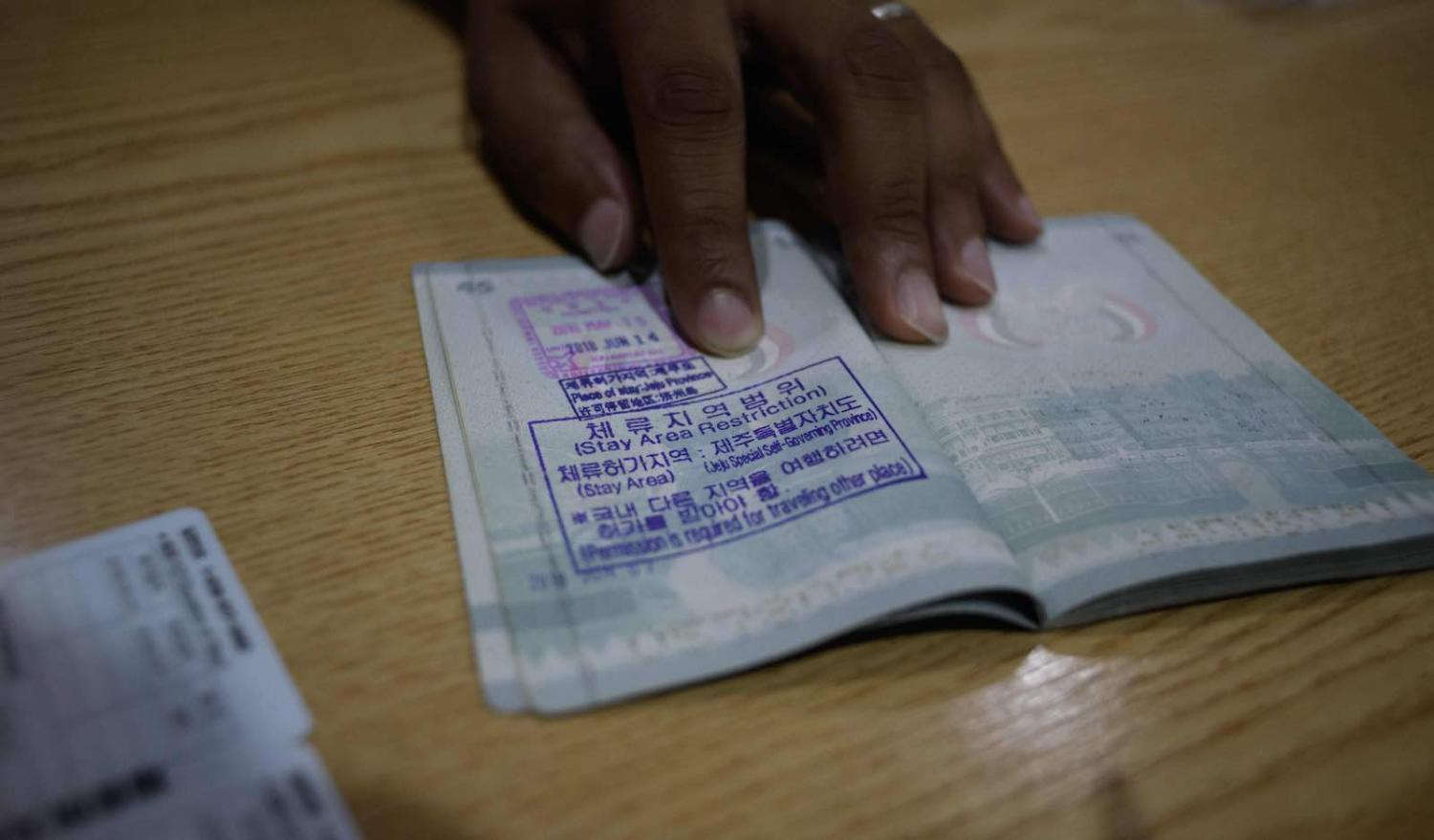 A Yemeni asylum seeker shows a South Korean visa in his passport in Jeju (Photo: Ed Jones via Getty)