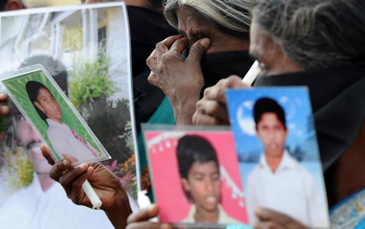 Sri Lankan Tamil mothers from the “Dead and Missing Person’s Parents” group hold photographs in Jaffna, November 2013 (Photo: Lakruwan Wanniarachchi via Getty)