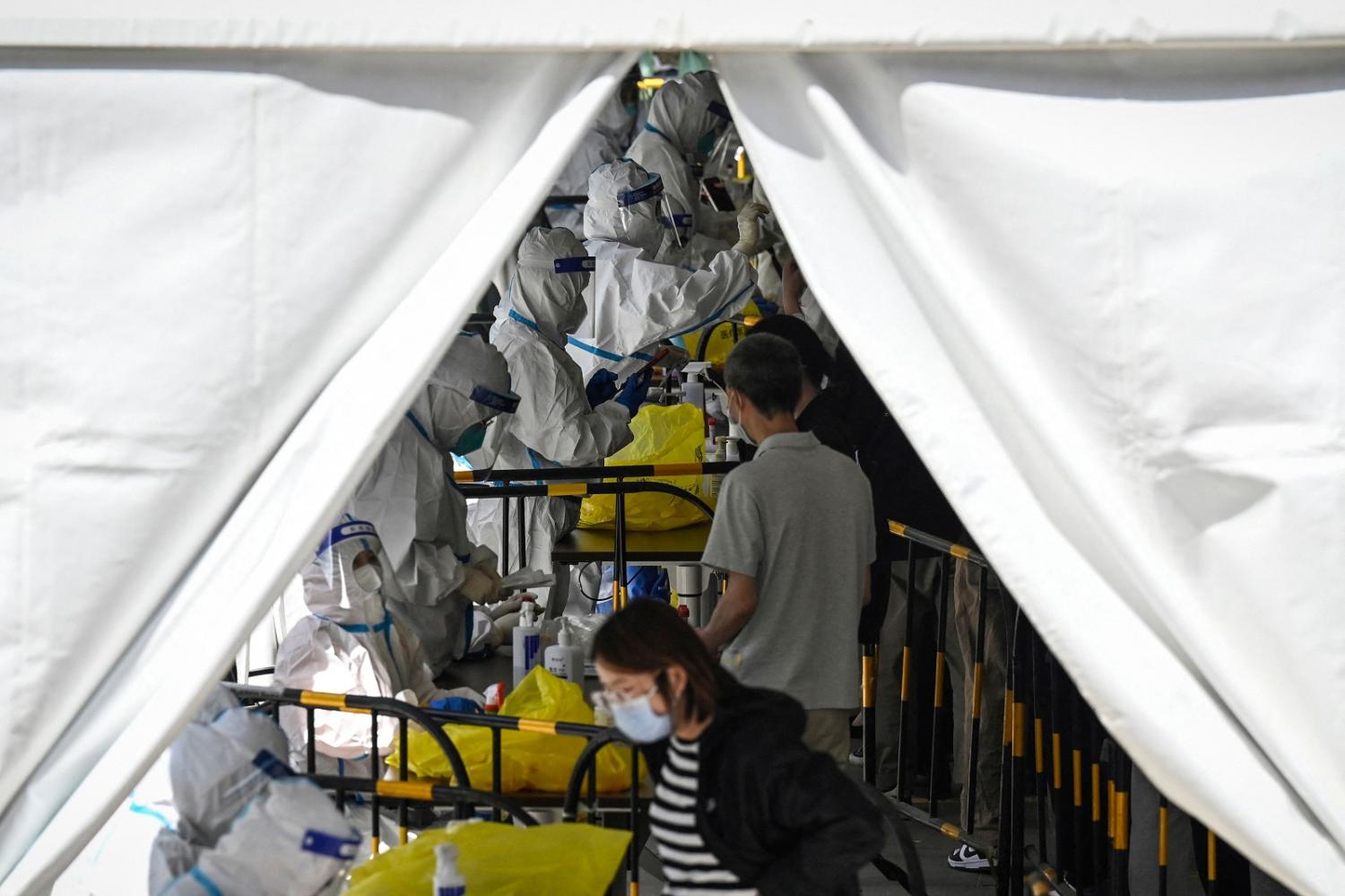 Health workers conduct Covid-19 testing at a makeshift site in Zhongguancun in Beijing, 26 April 2022 (Jade Gao/AFP via Getty Images)