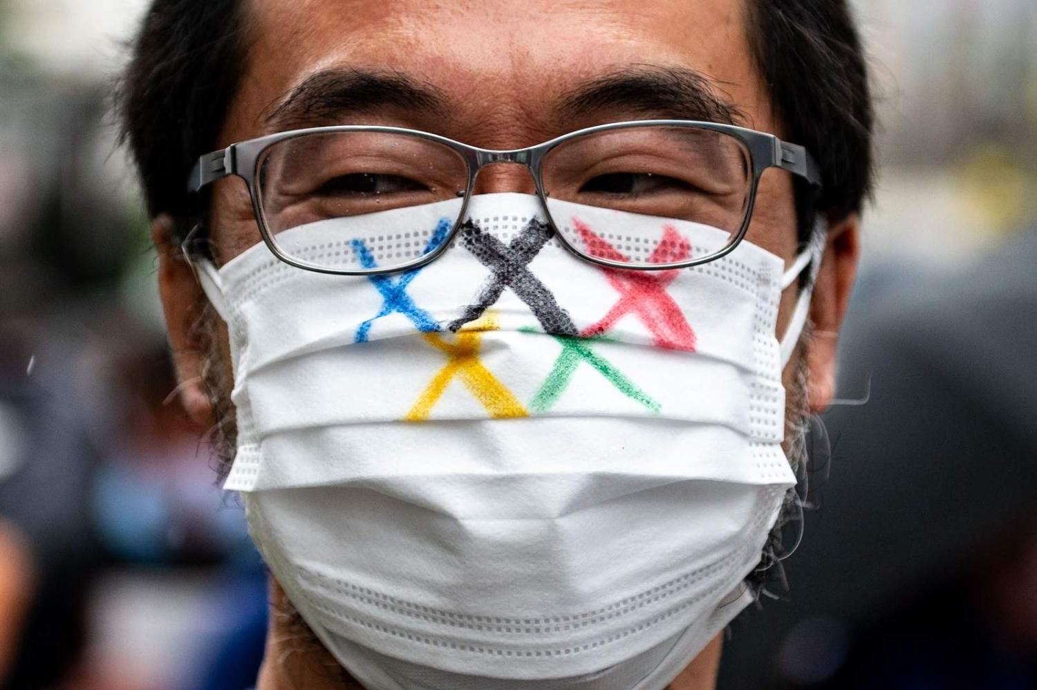 An activist marches to Tokyo's Metropolitan Government Building to protest against the Tokyo Olympics, 19 June 2021 (Philip Fong/AFP via Getty Images)