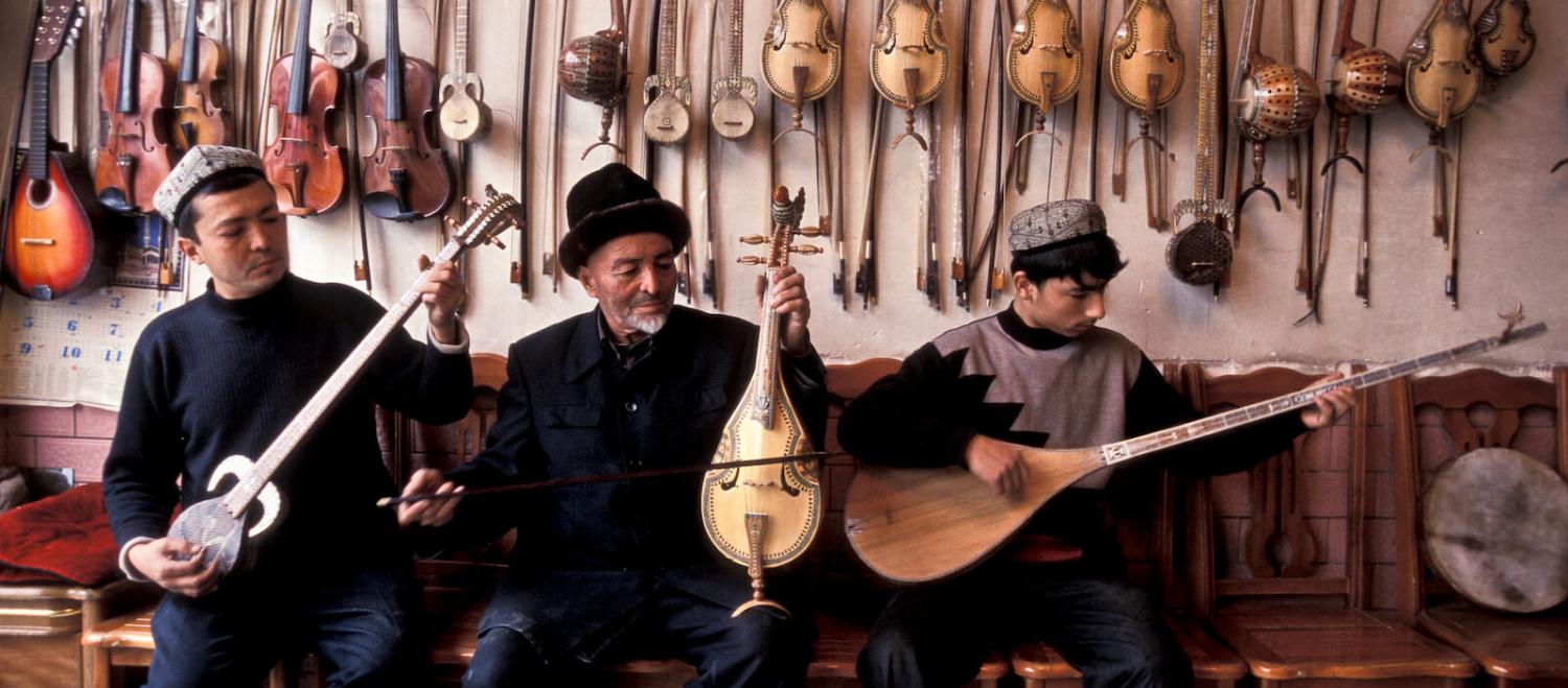 Ababekry Selay with son and employee playing traditional Uighur music in their shop in Kashgar city (Photo: Christopher Pillitz/Getty)