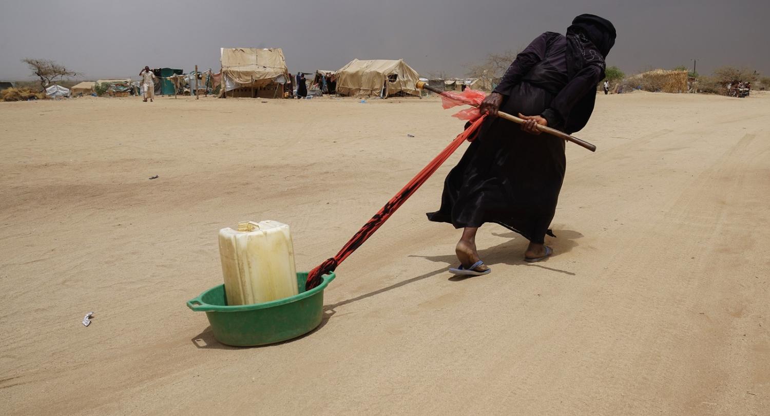 A displaced Yemeni woman drags water back to her tent in an ABS IDP camp. (Photo: Giles Clarke, UN OCHA/Getty Images)