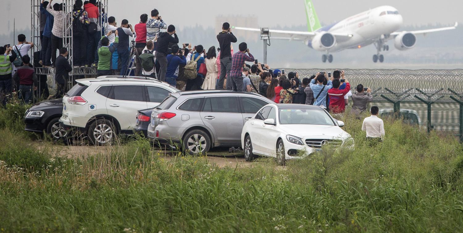 Enthusiasts watch the COMAC C919's maiden flight, 5 May 2017. (Getty/Bloomberg)