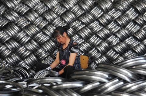 A worker checks wheel hubs of baby carriages set for export at a factory in Hangzhou in China’s eastern Zhejiang province (AFP via Getty Images)