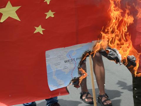 Protesters burn a mock Chinese flag with a map of the South China sea outside the Chinese consulate in Manila last year (Ted Aljibe/AFP via Getty Images)