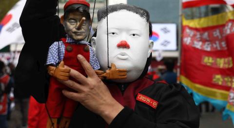 A protester in Seoul wearing a Kim Jong-un mask holds a doll of South Korea’s Moon Jae-in (Photo: Chung Sung-Jun/Getty)