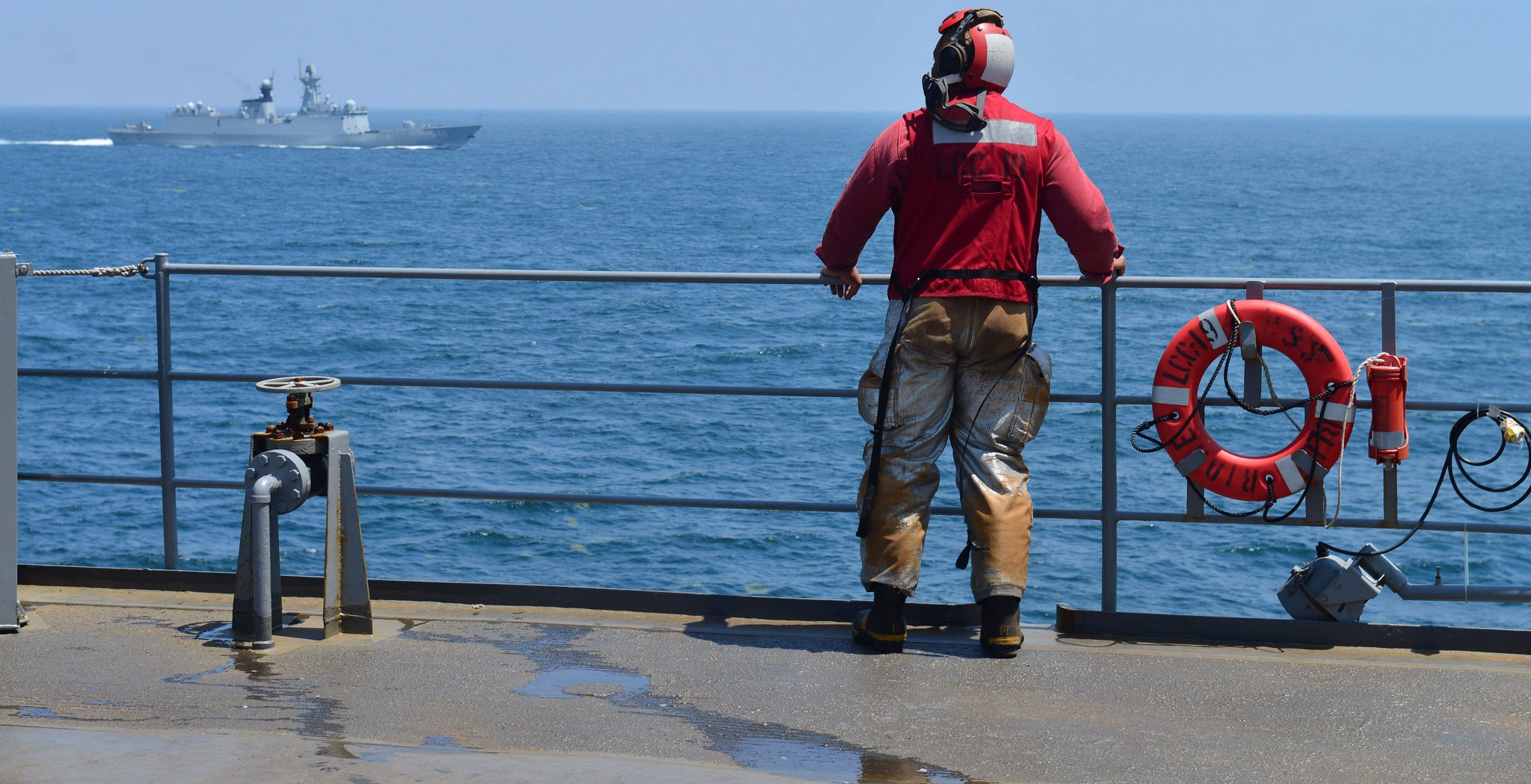 A US Navy sailor watches a PLA Navy frigate during a search and rescue exercise, 2014. (Flickr/US Pacific Fleet)